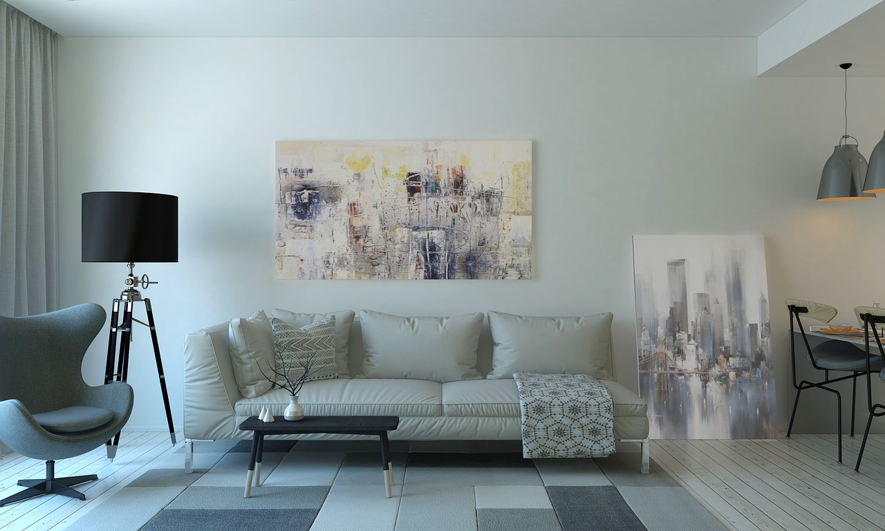 A bright apartment living room with a grey sofa, armchair and large windows