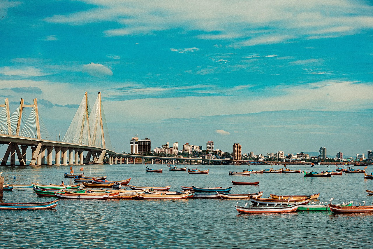Colourful fishing boats on the water with the Sea Link and the city skyline beyond